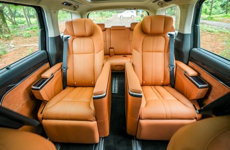 Business-class chairs on the second row offer 16 adjustability functions along with heating, ventilation, and massage. Plentiful stowage spaces, front footrest, and ottoman enhance occupant comfort.